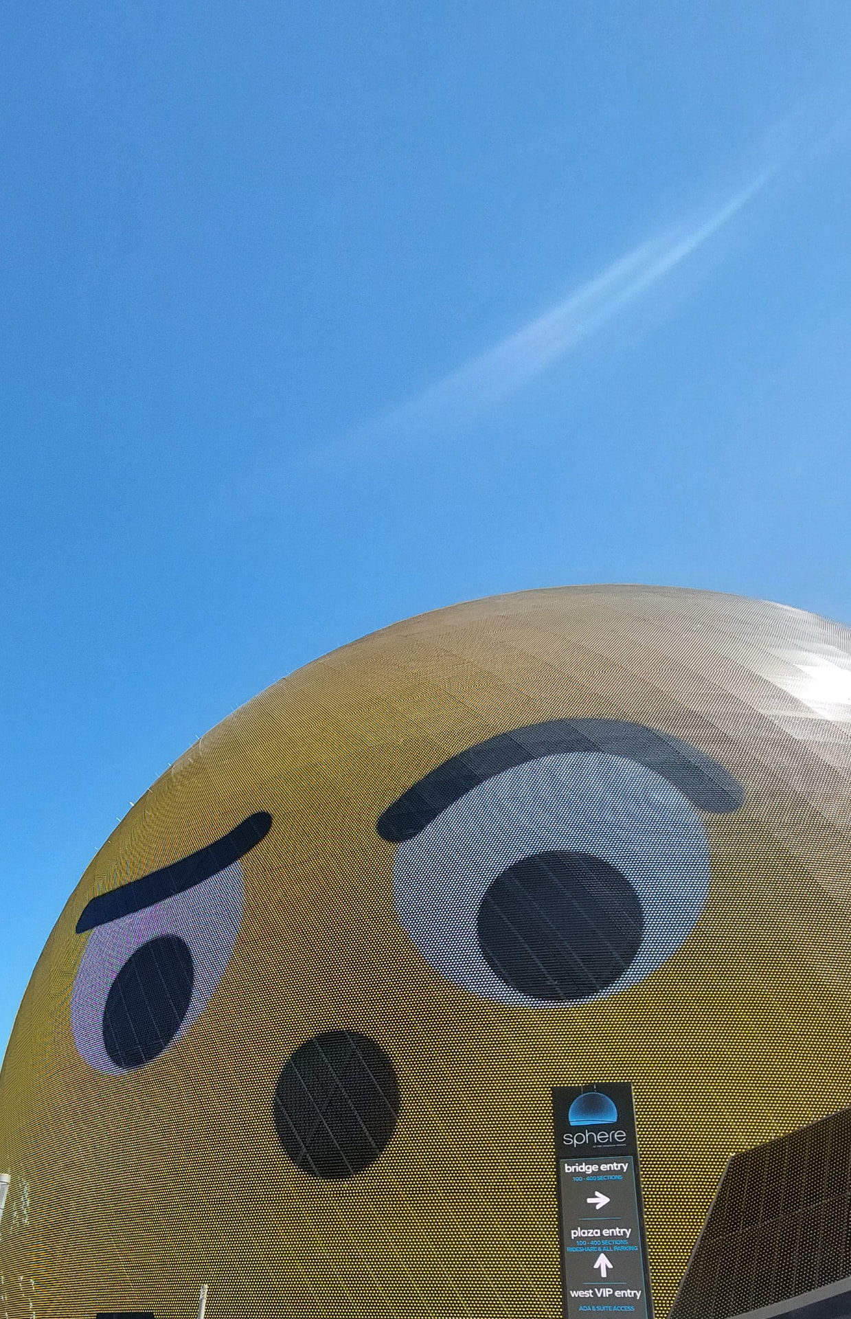 The Sphere in Las Vegas met een expressief gezicht tegen een blauwe lucht